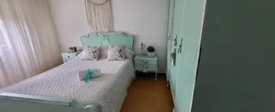 a small bedroom with a bed with a green headboard at Olimphya in Ourense