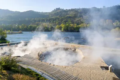 a fire pit with steam in the middle of a river at Olimphya in Ourense
