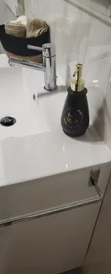 a black soap dispenser on a white bathroom sink at Olimphya in Ourense