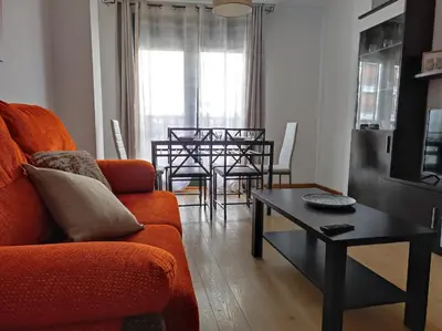 a living room with an orange couch and a table at Porto do Rio in Caldas de Reis