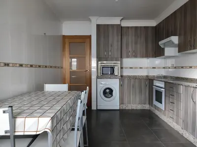 a kitchen with a table and a washing machine at Porto do Rio in Caldas de Reis