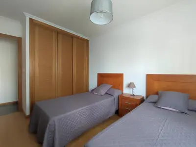 a bedroom with two beds and a night stand with a lamp at Porto do Rio in Caldas de Reis
