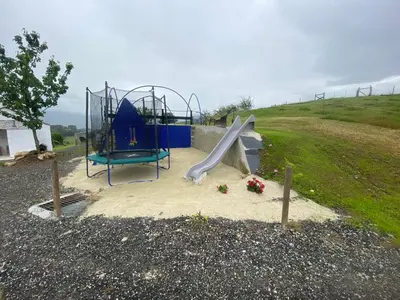 a playground with a slide in a field at Casa Darivas in Trabada