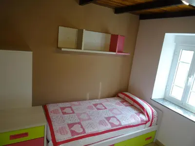 a small bedroom with a bed and a window at Casa Darivas in Trabada