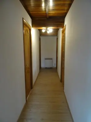 an empty hallway with wooden ceilings and doors at Casa Darivas in Trabada
