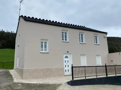 a white house with a black fence in front of it at Casa Darivas in Trabada