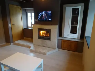 a living room with a fireplace with a tv above it at Casa Darivas in Trabada