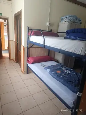 a dorm room with three bunk beds in it at Albergue La Senda in Rabanal del Camino