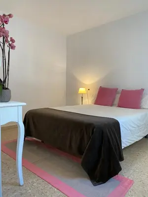 a bedroom with a bed with red pillows and a table at Apartamento Padrón Centro P3 by URent in Padrón