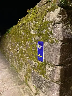 a sign on the side of a stone wall at Apartamento Padrón Centro P3 by URent in Padrón