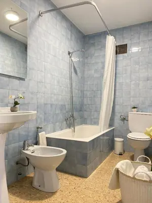 a bathroom with a tub and a toilet and a sink at Apartamento Padrón Centro P3 by URent in Padrón