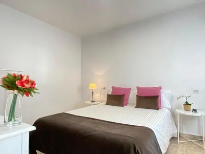 a bedroom with a large bed with pink pillows at Apartamento Padrón Centro P3 by URent in Padrón