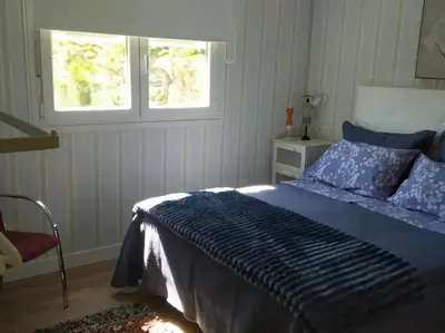 a bedroom with a blue bed and a window at Charming House in Parada with Large Garden in Parada