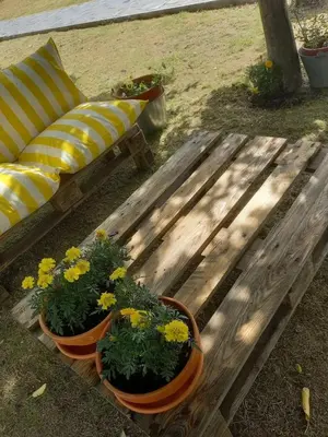 a wooden bench with flowers on it next to a couch at Charming House in Parada with Large Garden in Parada