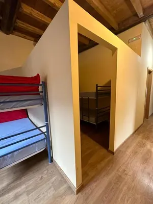 a room with bunk beds and a mirror at Albergue de peregrinos Compostela in Molinaseca