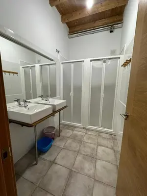 a bathroom with two sinks and two mirrors at Albergue de peregrinos Compostela in Molinaseca