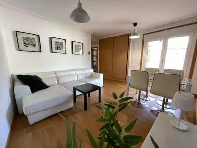 a living room with a white couch and a table at Apartamento a 5 min caminando de la Playa Sta. Cristina, Oleiros (Terraza, Parkin, ) in Oleiros