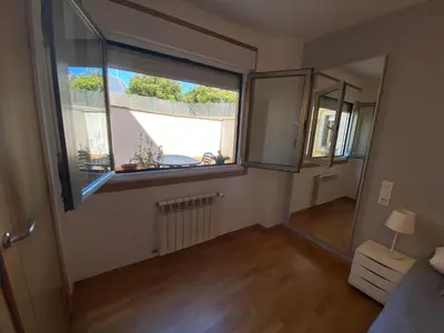 an empty room with a large window and a bedroom at Apartamento a 5 min caminando de la Playa Sta. Cristina, Oleiros (Terraza, Parkin, ) in Oleiros