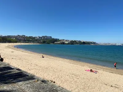 a group of people on a beach near the water at Apartamento a 5 min caminando de la Playa Sta. Cristina, Oleiros (Terraza, Parkin, ) in Oleiros