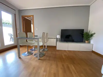 a living room with a table and chairs and a television at Apartamento a 5 min caminando de la Playa Sta. Cristina, Oleiros (Terraza, Parkin, ) in Oleiros