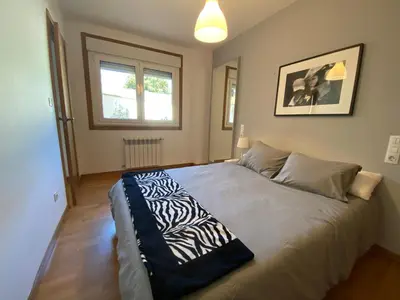 a bedroom with a bed with a zebra blanket on it at Apartamento a 5 min caminando de la Playa Sta. Cristina, Oleiros (Terraza, Parkin, ) in Oleiros