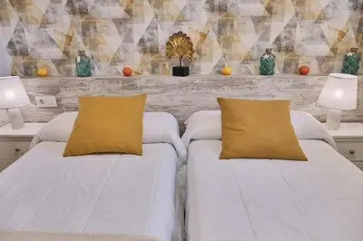 a bedroom with two white beds and two lamps at Pensión A Solaina 2 in O Pino