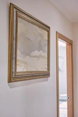a painting hanging on a wall next to a mirror at Pensión A Solaina 2 in O Pino
