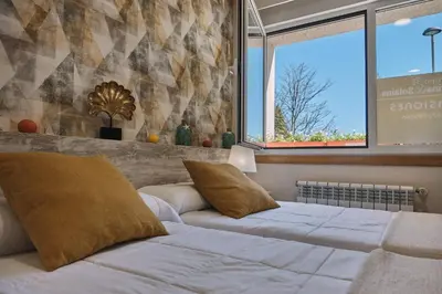 a bedroom with two beds and a window at Pensión A Solaina 2 in O Pino