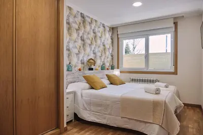 a bedroom with a large bed and a window at Pensión A Solaina 2 in O Pino