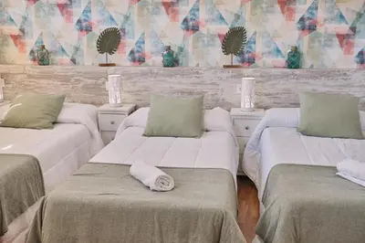 a room with three beds with towels on them at Pensión A Solaina 2 in O Pino
