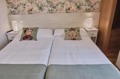 a bedroom with two beds and two night stands at Pensión A Solaina 3 in O Pedrouzo