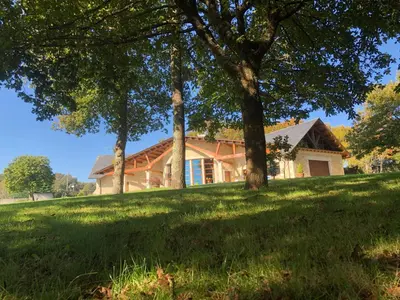 a house on a hill with trees in front of it at Hotel Batán in Villalba