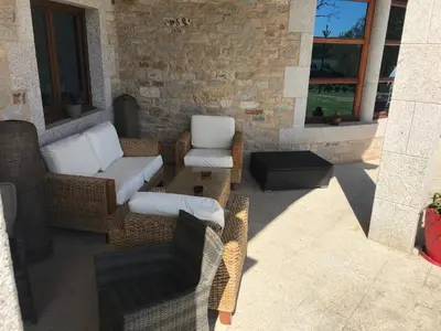 a patio with chairs and a couch and a table at Hotel Batán in Villalba