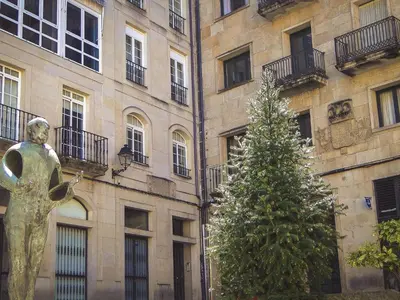 a christmas tree in front of a building with a statue at Apartment in Ourense near Hot Springs in Ourense