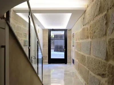 a hallway with a black door and a stone wall at Apartment in Ourense near Thermal Baths in Ourense