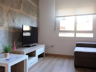 a living room with a television on a desk with a couch at Apartment in Ourense near Thermal Baths in Ourense
