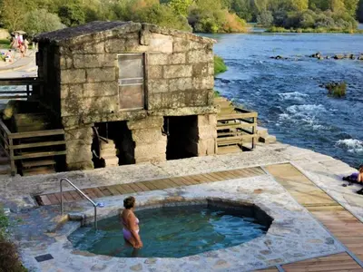 a man standing in a hot tub next to a river at Apartment in Ourense near Thermal Baths in Ourense