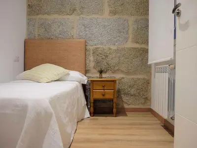 a bedroom with a bed and a nightstand and a brick wall at Apartment in Ourense near Hot Springs in Ourense