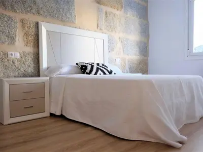 a bedroom with a white bed and a mirror at Apartment in Ourense near Hot Springs in Ourense
