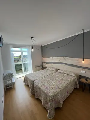 a bedroom with a bed and a large window at ENTRECAMIÑOS in O Pedrouzo