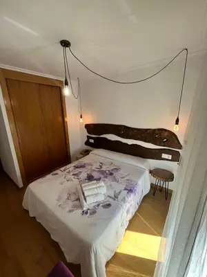 a bedroom with a bed and a chandelier at ENTRECAMIÑOS in O Pedrouzo