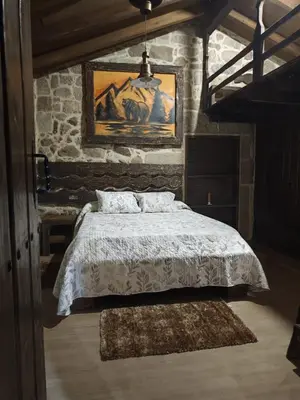 a bedroom with a bed in a stone wall at CASERIO RECTORAL DESTERIZ in Ourense