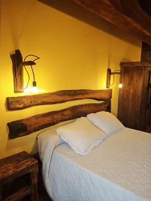 a bedroom with a white bed with two pillows at CASERIO RECTORAL DESTERIZ in Ourense