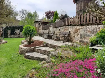 a stone wall with a bench in a garden at Apartamentos Alburiñas Ribeira Sacra in Bolmente