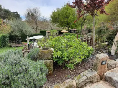 a garden with some bushes and a wooden fence at Apartamentos Alburiñas Ribeira Sacra in Bolmente