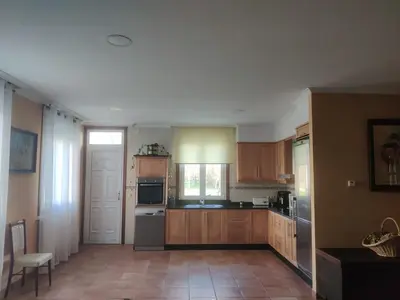 a kitchen with wooden cabinets and stainless steel appliances at Casa a Trepa in Villar de Barrio