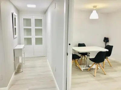 a hallway with a table and chairs in a room at Apartamento Muralla in Lugo
