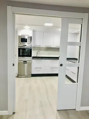a kitchen with white cabinets and stainless steel appliances at Apartamento Muralla in Lugo