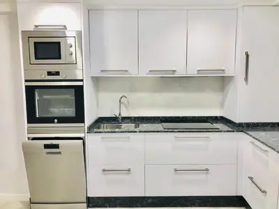 a white kitchen with a sink and a microwave at Apartamento Muralla in Lugo