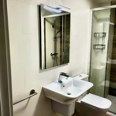 a bathroom with a sink and a toilet and a mirror at Apartamento Muralla in Lugo